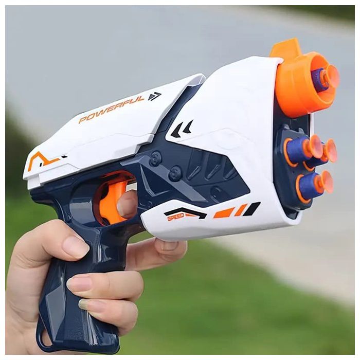 Toy gun with orange darts held by a hand against a blurred green background